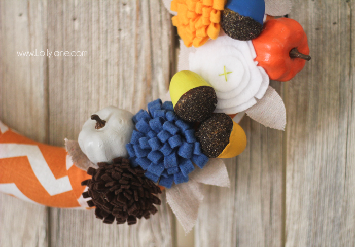 DIY Fall wreath tutorial. Love these felt flowers and painted pumpkins to create this pretty fabric fall wreath!