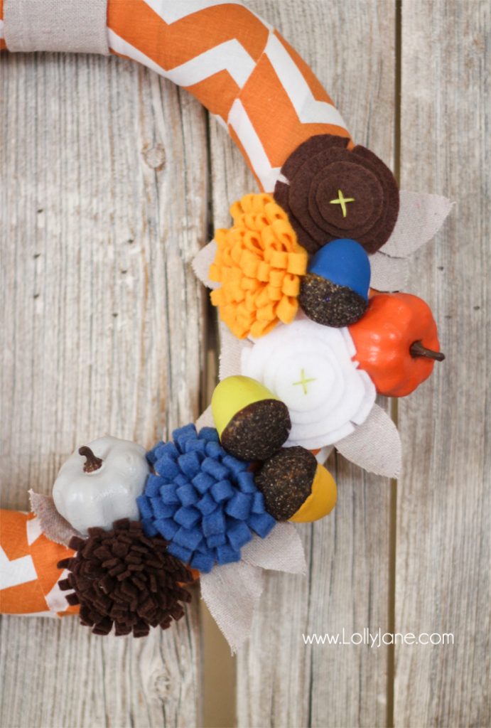 DIY Fall wreath tutorial. Love these felt flowers and painted pumpkins to create this pretty fabric fall wreath!