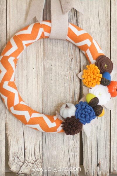 DIY Fall wreath tutorial. Love these felt flowers and painted pumpkins to create this pretty fabric fall wreath! #falldecor #fallwreath #falldecorations #chevronwreath #acorndecor
