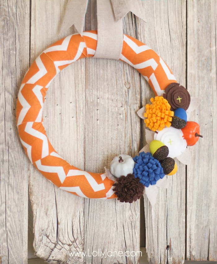 DIY Fall wreath tutorial. Love these felt flowers and painted pumpkins to create this pretty fabric fall wreath! #falldecor #fallwreath #falldecorations #chevronwreath #acorndecor