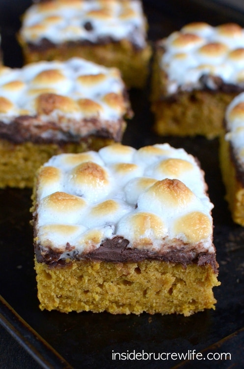 Pumpkin S’mores Bars: Spicy pumpkin cake bars topped with melted chocolate and gooey marshmallows are the perfect dessert for bringing summer into fall. #falldessert #fallrecipe #pumpkinbars #pumpkindessert #pumpkinsmores #smoresbars #smoresdessert #fallrecipe #falldessert