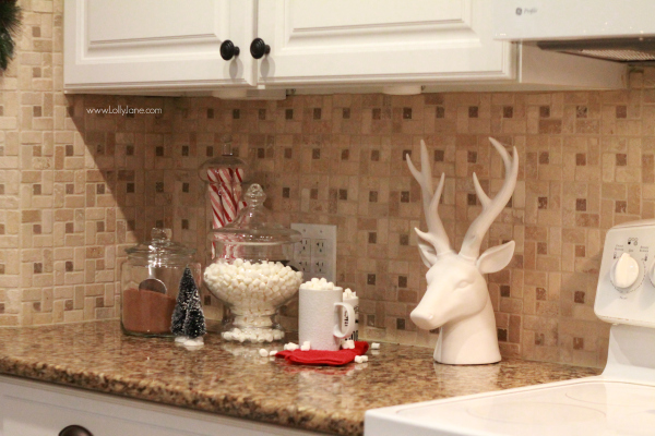 Jars filled with cocoa and mallows for quick hot cocoa on a cold night. Cute way to dress up your kitchen. Click through for cute Christmas kitchen decor ideas.