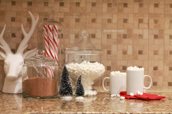 Jars filled with cocoa and mallows for quick hot cocoa on a cold night. Cute way to dress up your kitchen. Click through for cute Christmas kitchen decor ideas.