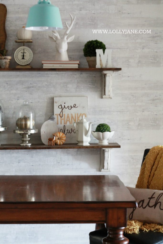 Beautiful farmhouse Thanksgiving dining room decorations. Decorate the table and shelves in layers of pumpkins and signs, fill in with greenery, books and pinecones. Cute Thanksgiving decor ideas that you can easily copy!