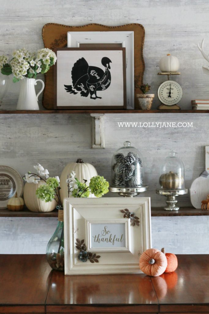 Beautiful farmhouse Thanksgiving dining room decorations. Decorate the table and shelves in layers of pumpkins and signs, fill in with greenery, books and pinecones. Cute Thanksgiving decor ideas that you can easily copy!