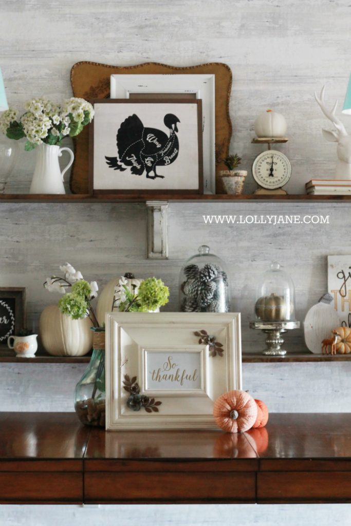 Beautiful farmhouse Thanksgiving dining room decorations. Decorate the table and shelves in layers of pumpkins and signs, fill in with greenery, books and pinecones. Cute Thanksgiving decor ideas that you can easily copy!