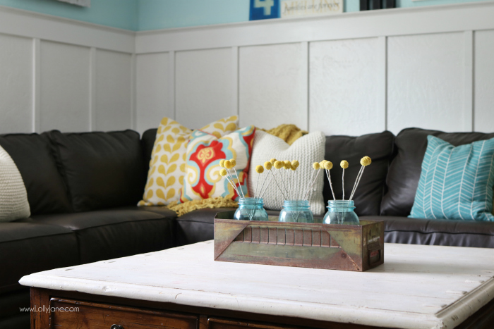 Pretty colorful farmhouse family room decor. Easy ways to pull together a family room space. Pretty farmhouse decor ideas. Love this colorful family room! These billy balls in vintage blue mason jars are such cute decor too.