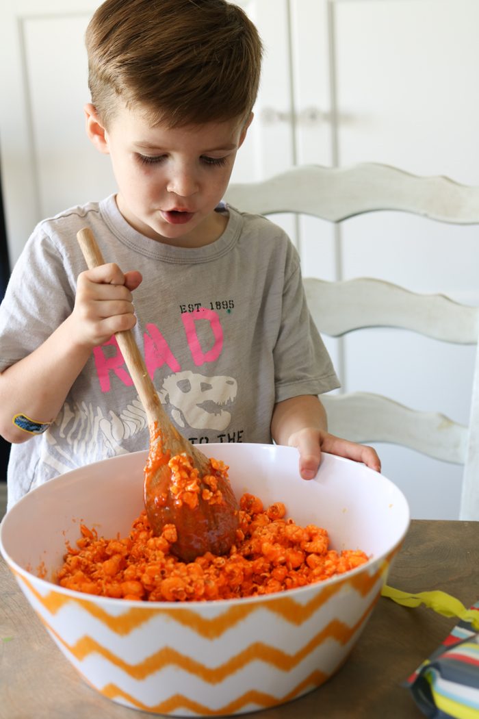 Easy and YUMMY Candy Covered Halloween Popcorn! Perfect for little hands to help in the kitchen, then bag up for a spooky treat!