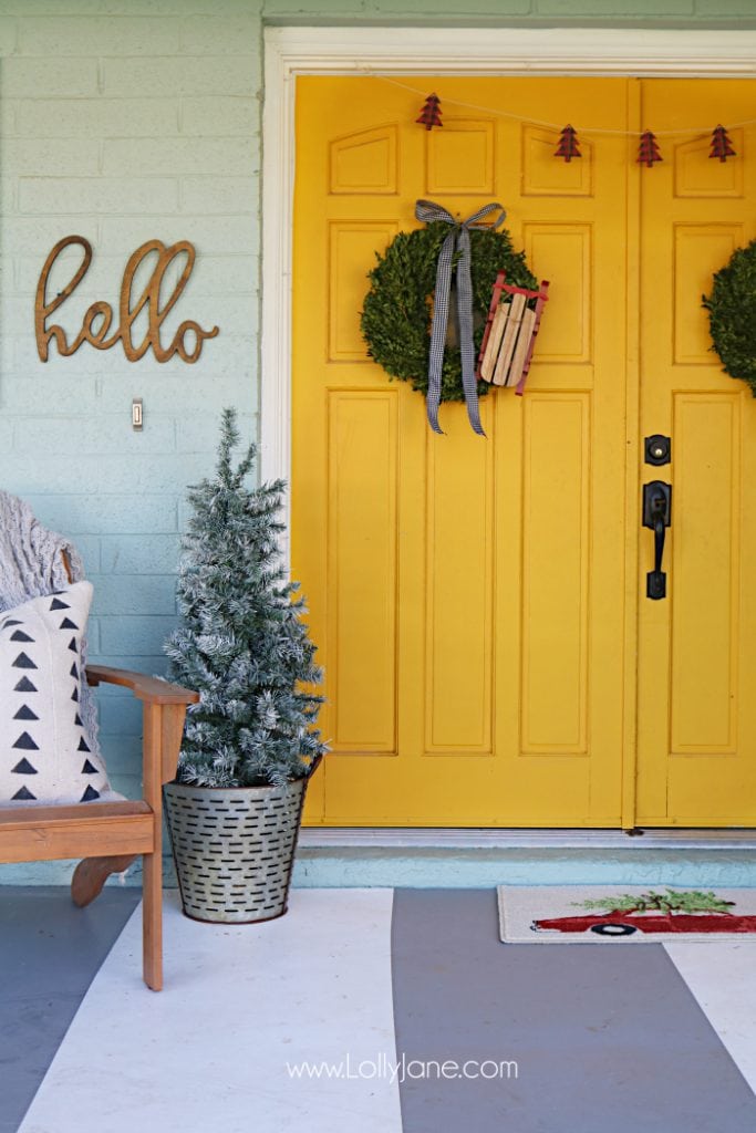 yellow front doors with Christmas wreaths