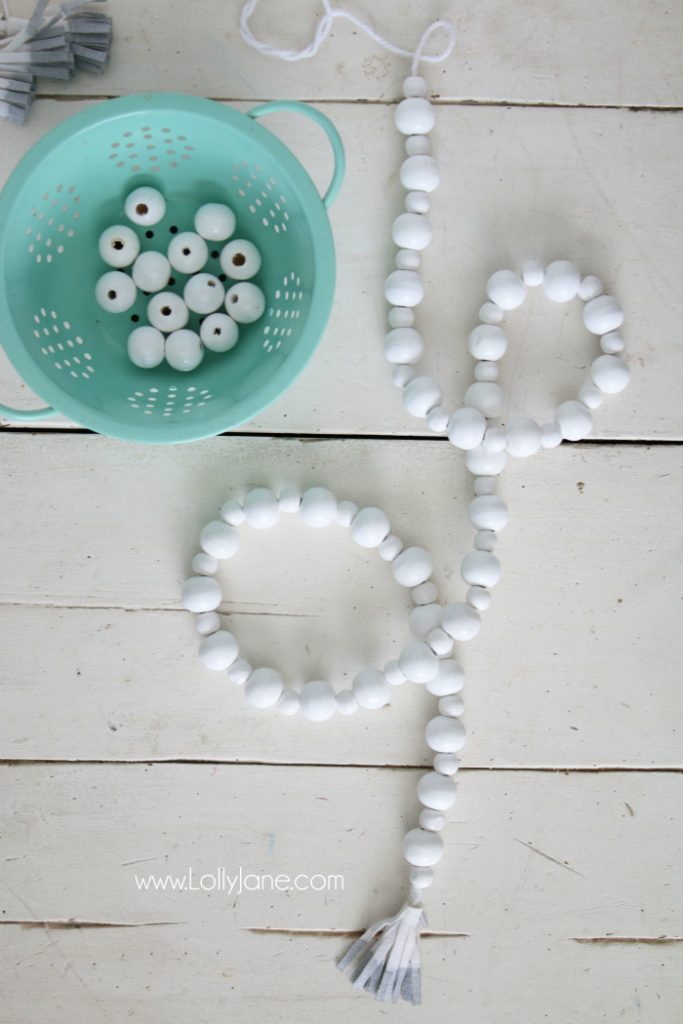 DIY How to make a wood bead garland. Jump on this hot home decor trend of wood beads! Accessorize your home decor with cute wood bead garlands and for less than $5! Love these diy wood bead garlands!