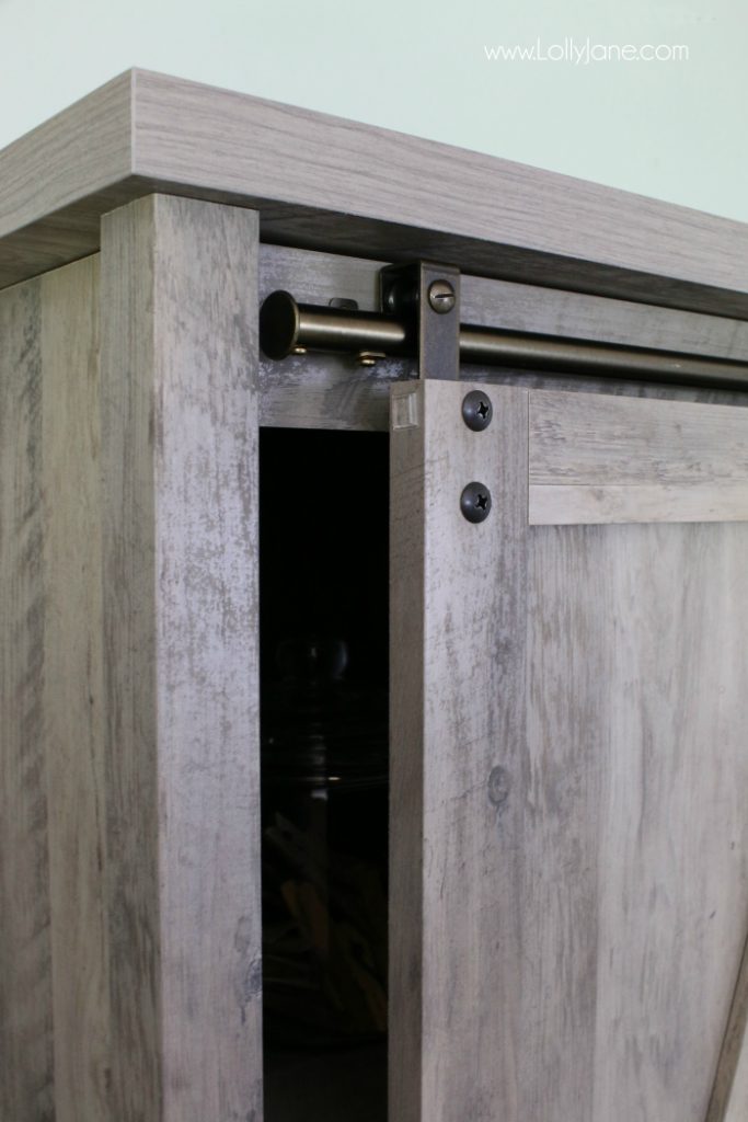 This sliding barndoor farmhouse cabinet is so cute! Love this modern farmhouse decor, completes this laundry room makeover so well!