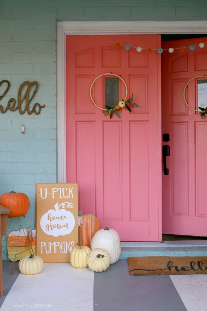 These coral doors make a big statement on this farmhouse, love the pile of pumpkins at the door!