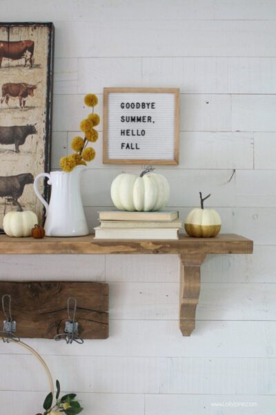 Cute pops of fall on this mantel! Love the vintage scale!