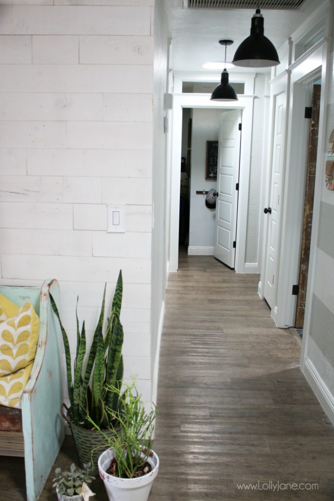 Such a pretty farmhouse hallyway with shiplap walls and pretty barn light pendants!