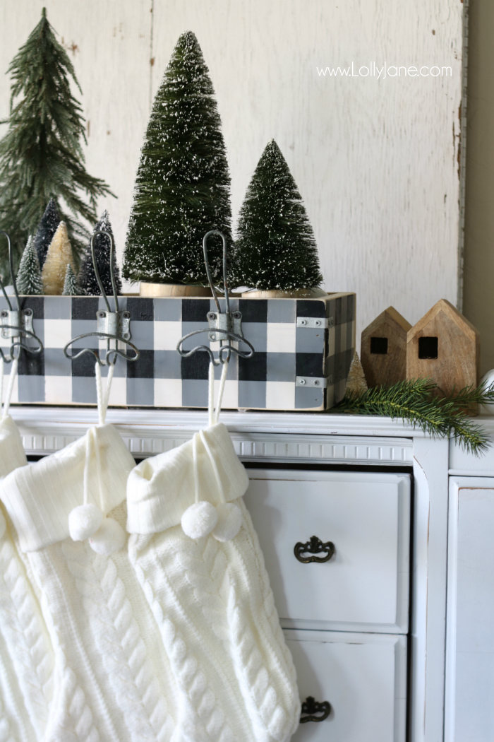 How to make a wooden stocking holder. Paint it in buffalo check for pretty Christmas farmhouse style! Love these bottle brush trees and Magnolia wood houses!