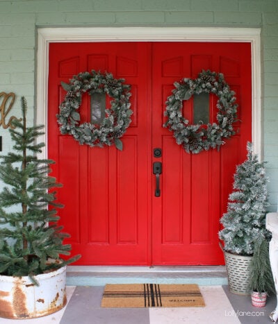 Pretty Christmas front porch decor ideas. Lots of greenery, signs and cheer to this old farmhouse Christmas porch!