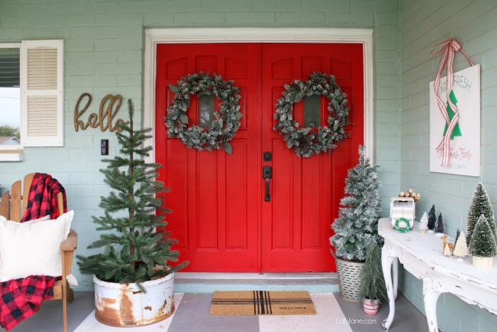 Pretty Christmas front porch decor ideas. Lots of greenery, signs and cheer to this old farmhouse Christmas porch!