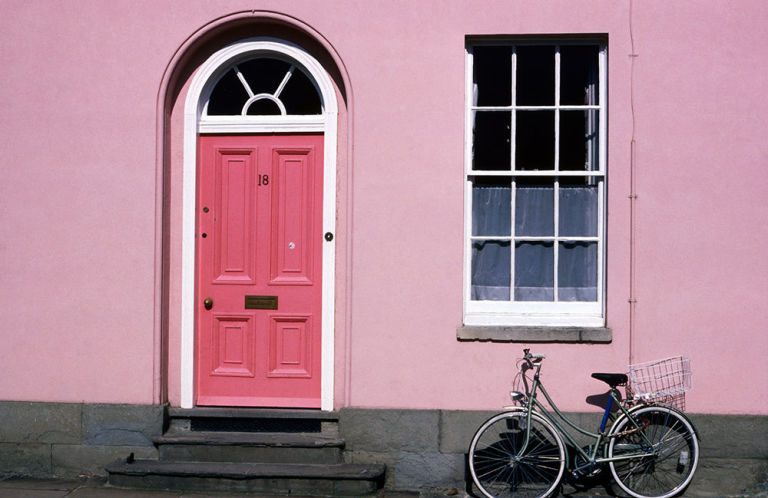 Check out this hot pink door on a soft pink exterior house. Love this combo of bold and modern! Such a pretty pink house with a darling hot pink front door!