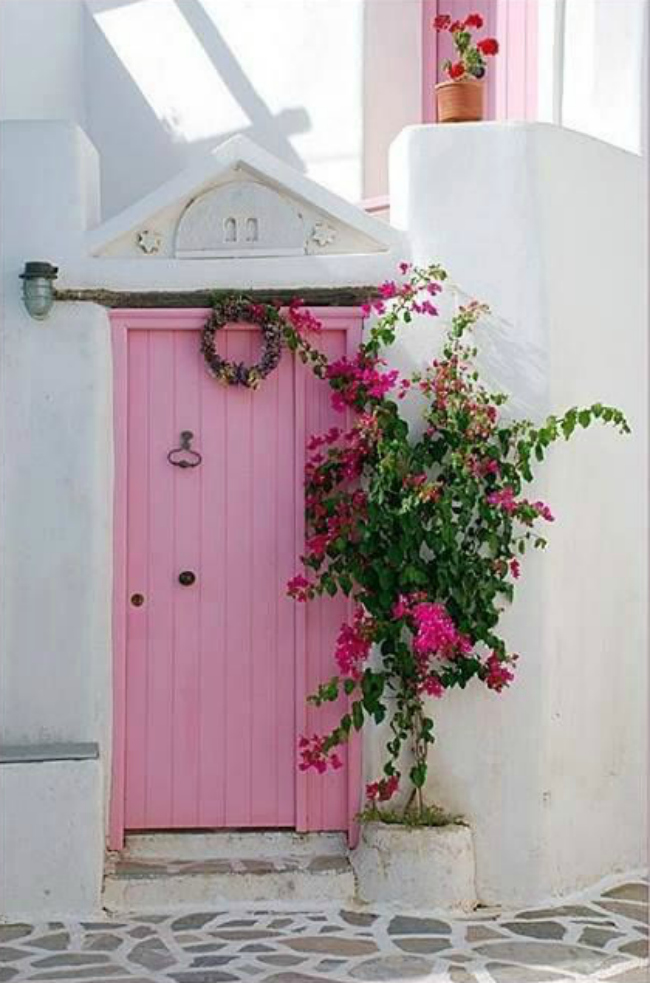 Dying over this bright pink door with a south american feel entryway. Such a pretty combo of the pink and white brick!