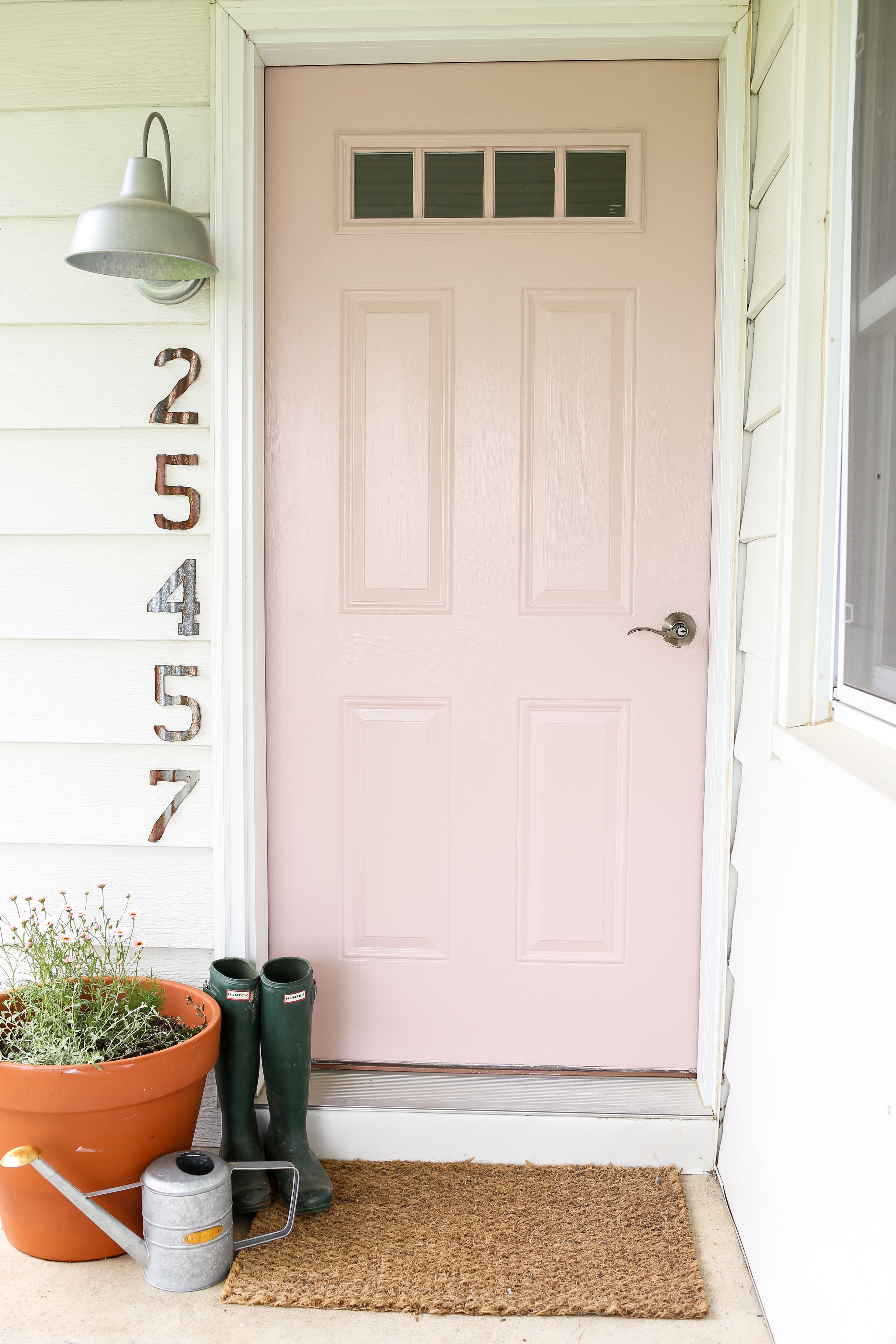 Geez louise this pink front door is precious! Adore this pink exterior door! Such a happy front porch!