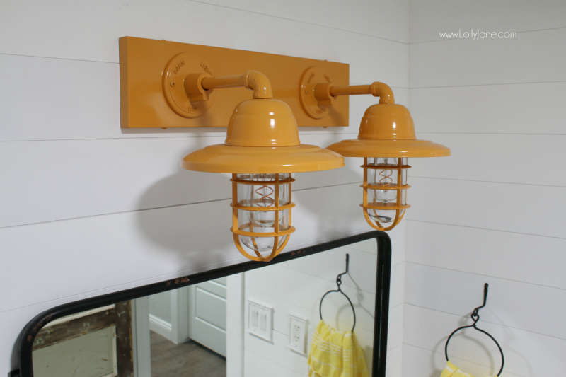 These yellow farmhouse bathroom vanity lights add a pop of color to a muted farmhouse bathroom renovation, so fun!