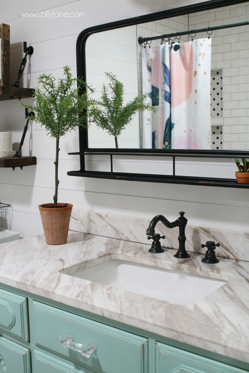 Such a fun farmhouse bathroom guest decor ideas! Loving the bathroom accessories in this farmhouse bathroom with the colorful lights and blue vanity with the shiplap bathroom walls.