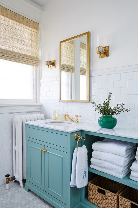 Love this dreamy bathroom decor with its turquoise bathroom vanity and modern brass finishes!