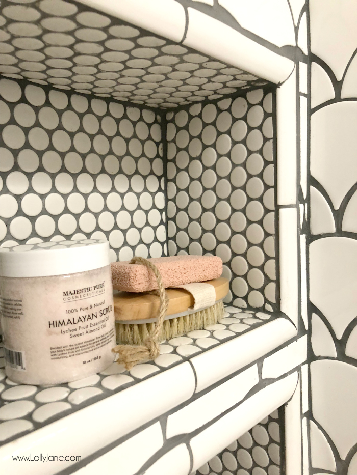 Love custom shower built-in shelves to provide storage! These pearl tiles with fan tile are the perfect combination in this glam farmhouse bathroom remodel!