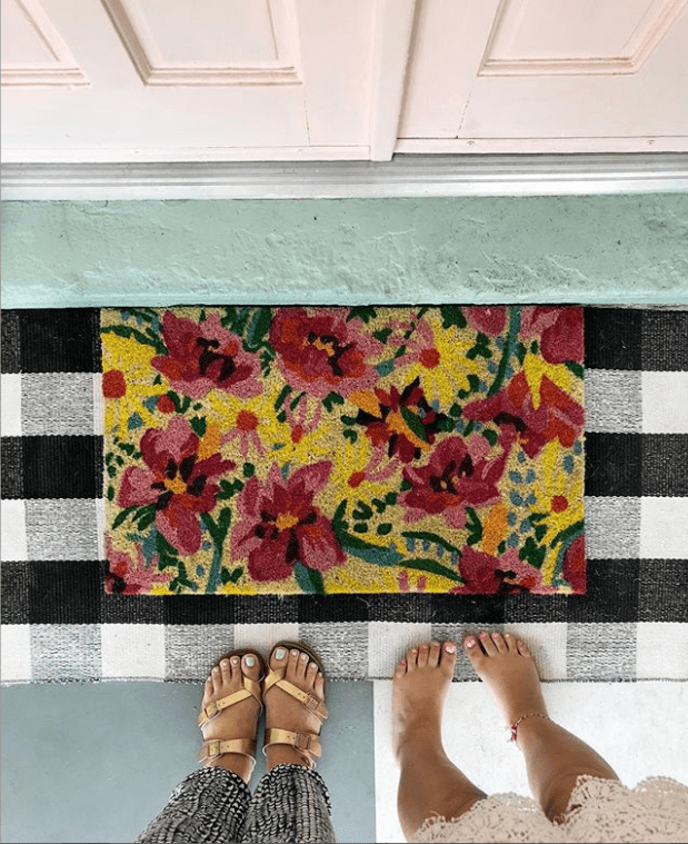 So in love with this layered buffalo check and floral rug welcome mat, such cute front porch decor! Cheery way to welcome guests by layering rugs! #outdoorspaces #welcomehome #buffalocheck #floralmat #welcomemat