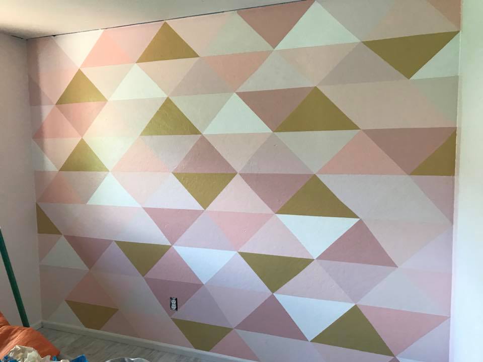 Such a cute painted triangle accent wall! LOVE this little girls bedroom accent wall. The cutest modern nursery wall, so cool! #diy #paintedwall #accentwall #trianglewall #homedecor #nurserydecor #girlsroom