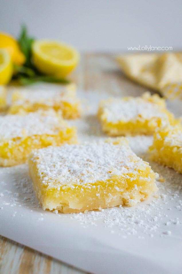 These melt-in-your-mouth lemon bars are bursting with citrus flavor. This is the perfect dessert recipe to whip up for big parties or gatherings any time of year. Family favorite lemon bars recipe, mm! #lemonbars #dessert #lemonrecip