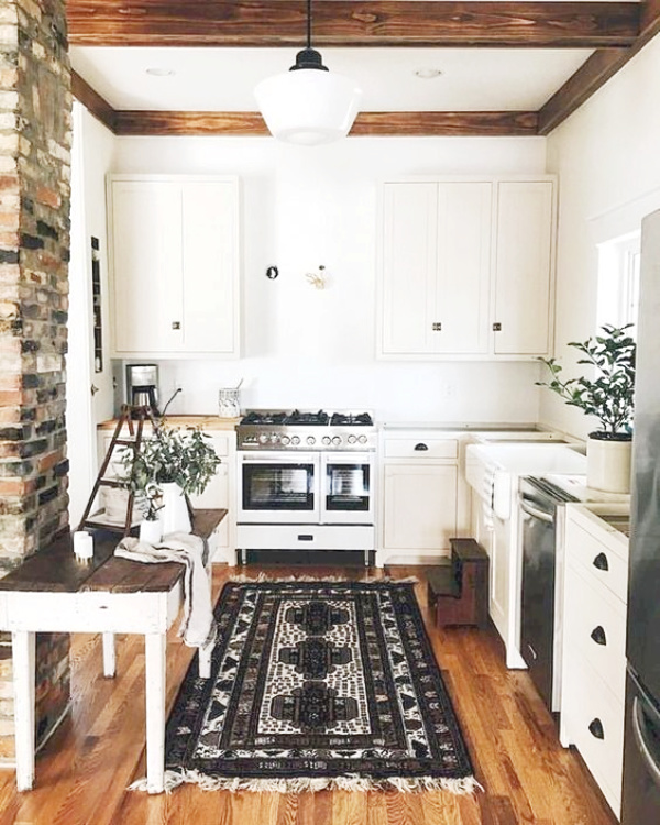 Farmhouse style kitchen rugs are really trendy right now and can really warm up a space. We love this modern farmhouse kitchen rug with white cabinet and wood floors, the patterned rug defines the style of this white farmhouse kitchen. #farmhousekitchen #whitekitchen #farmhousestylerug #modernfarmhouserug #farmhouserug #farmhousekitchenrug