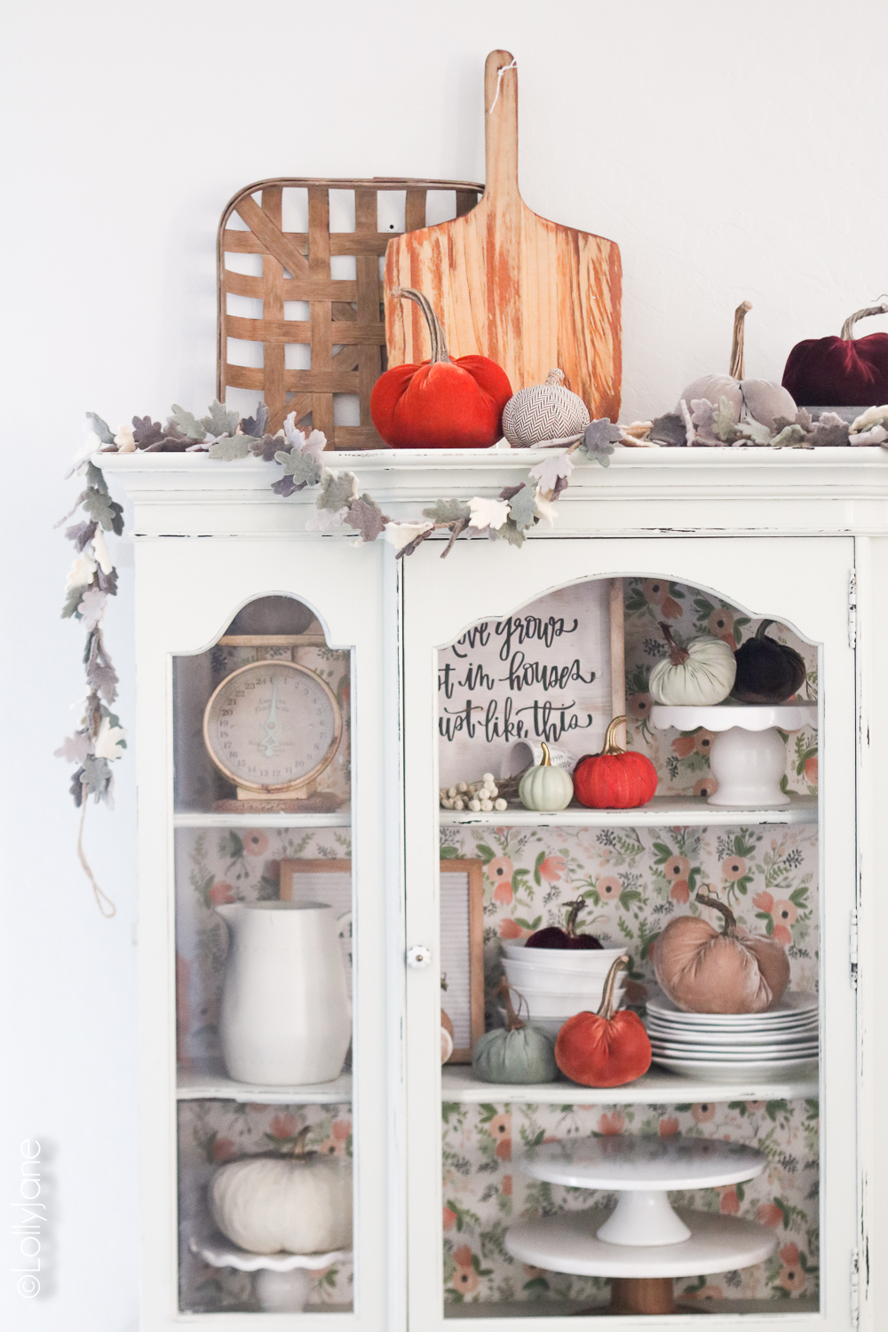 Simple fall decorations... a garland, plush pumpkins, and white dinnerwear make for a bright autumn space! Click to see 5 other fall homes, so beautiful! Add garland and plush pumpkins to your hutch, cabinet, or buffet for instant autumn warmth! #diy #falldecor #homedecor #fallhomedecor