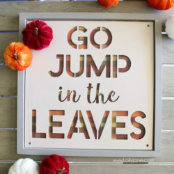 Love this plaid fall sign using buffalo check paper and a pre-made wood frame from the Simply Autumn line. This cute jump in the leaves wood sign is the perfect easy mantel decor when adding velvet pumpkins! #falldecor #plaidsign #buffalocheck #woodsign #falldecor #falldecorating #fallmanteldecor