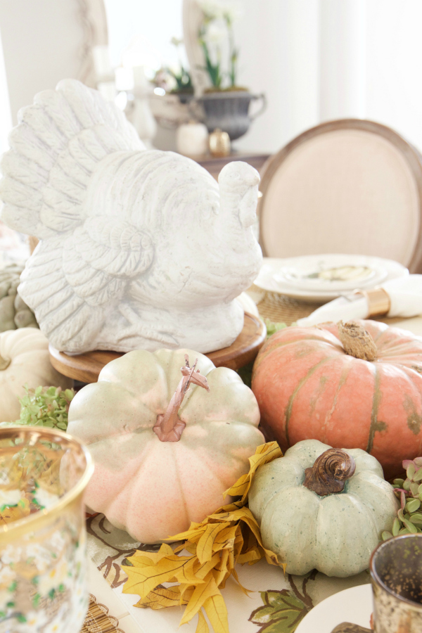  These pumpkins and gourds look so darling with a ceramic vintage style turkey, don't they? How fun to pile more and more gourds and faux flowers to the mix to create the perfect Thanksgiving centerpiece table decoration. #thanksgivingdecor #falldecor #pumpkindecor #thanksgivingcenterpiece