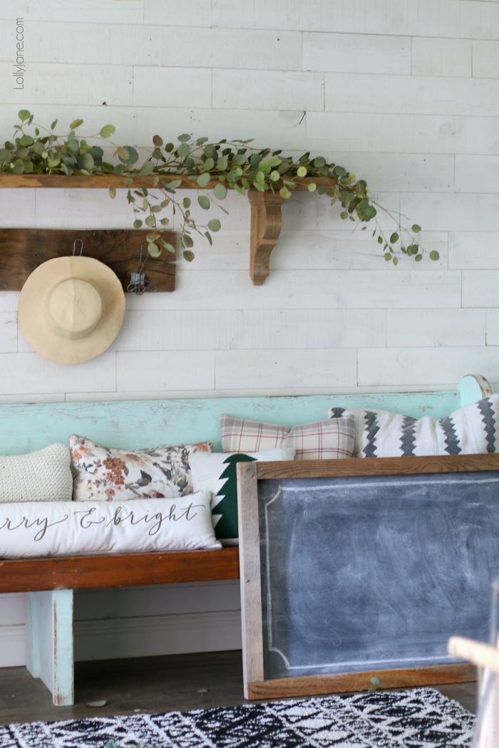 Scribble a Christmasy phrase or word on a chalkboard, add some eucalyptus branches + candles and BAM: Simple wintery Christmas mantel with chalk art... feel festive without all the frills! Click through to see how this was put together! #diy #christmasdecorations #winterdecor