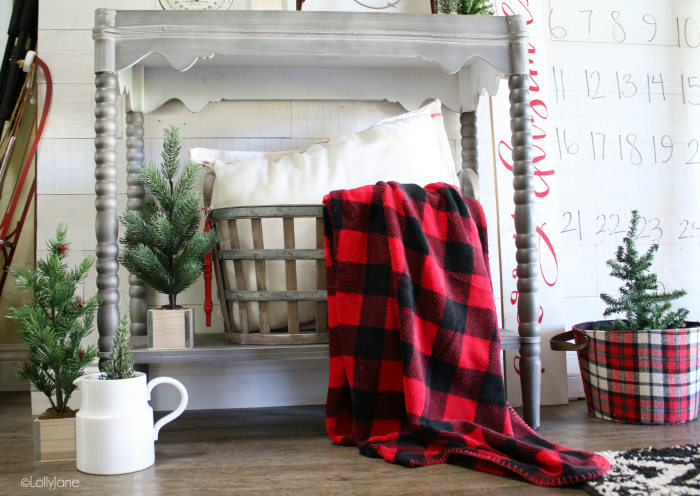 Love these easy Christmas entryway decorations using boxwood trees, a buffalo check throw and farmhouse basket! #christmas #christmasdecorations #christmasentryway