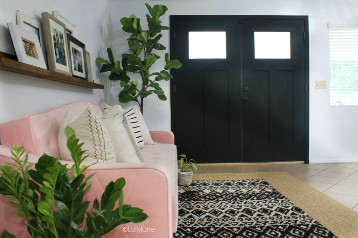 Boho living room decor with a fun pink tufted velvet couch and dark interior door! #bohochic #midcenturymodern #livingroomdecorideas