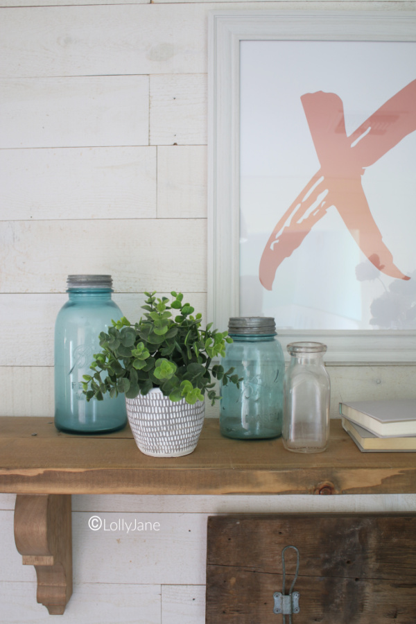 Blue mason jar Valentines Day decor ideas. Love pairing vintage blue jars with flowers to create an easy Valentines Day mantel. Love this Valentines Day entryway decor! #vintagevalentinesday #valentinesdaydecor #vdaydecor #vdaymantel #valentinesdaymantel #bluemasonjarcollection #pinkvaletinesdaydecor #masonjarflowerarrangement #masonjarflowers