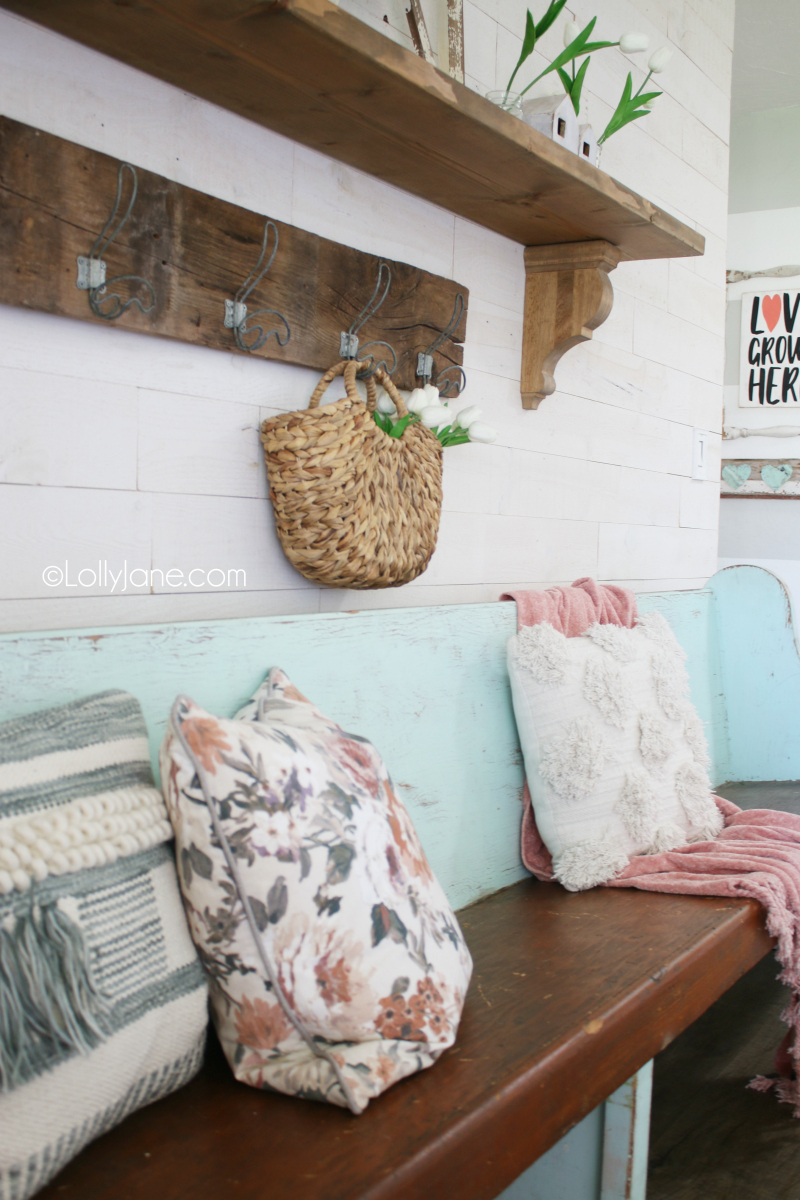 Spring mantel decor is easy to put together using fun spring linens like floral pillows, loop pillows and pink chenille throws with tulips and an old window. #springmantel #springdecor #oldwindow #farmhousespringmantel #springdecorations