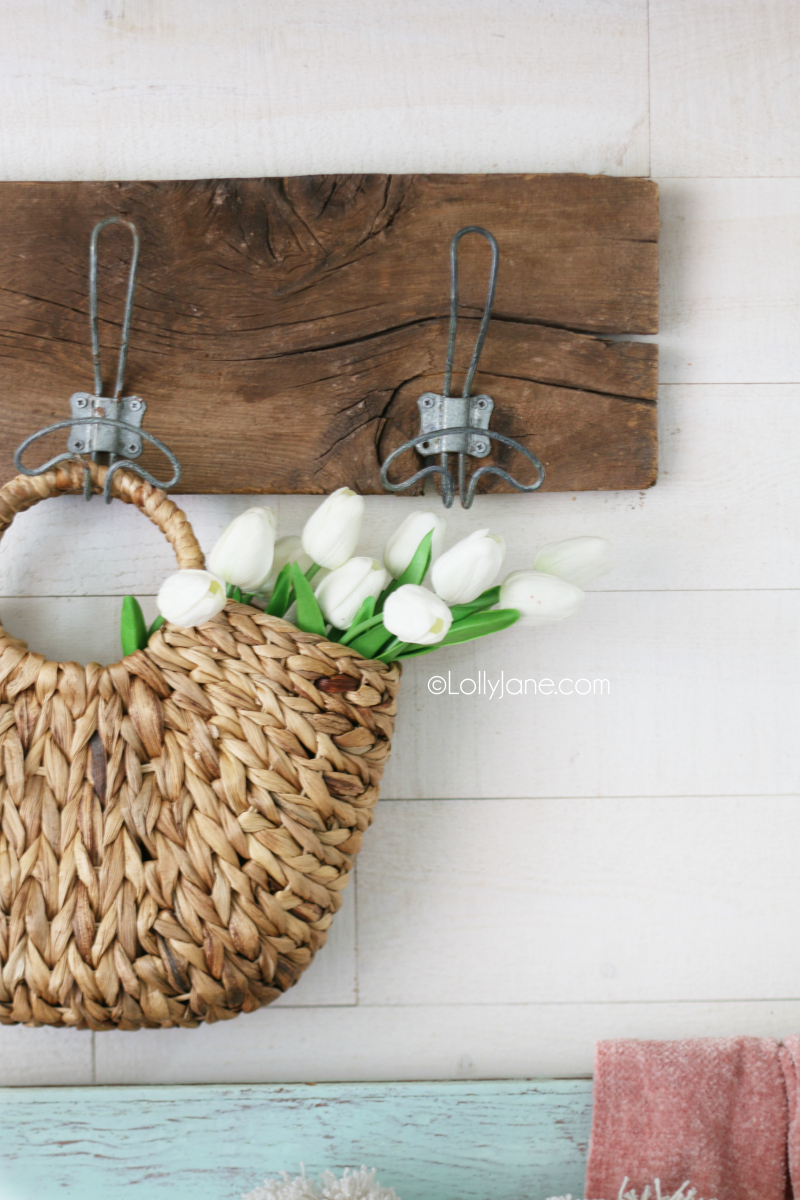 Decorating with tulips in a straw basket is a fun way to welcome spring decor. Put this simple spring mantel together with tulips, glass jars and an old chippy window. #springdecor #tulips #oldwindow #springdecorating #springmantel