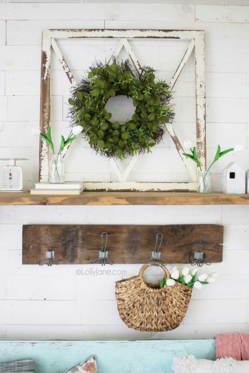 A beautiful vintage inspired, rustic spring mantel featuring an old window, tulips and natural wood accents. Love the vintage inspired farmhouse hooks, too! #springdecor #springmantel #springentryway #springdecorations #tulips