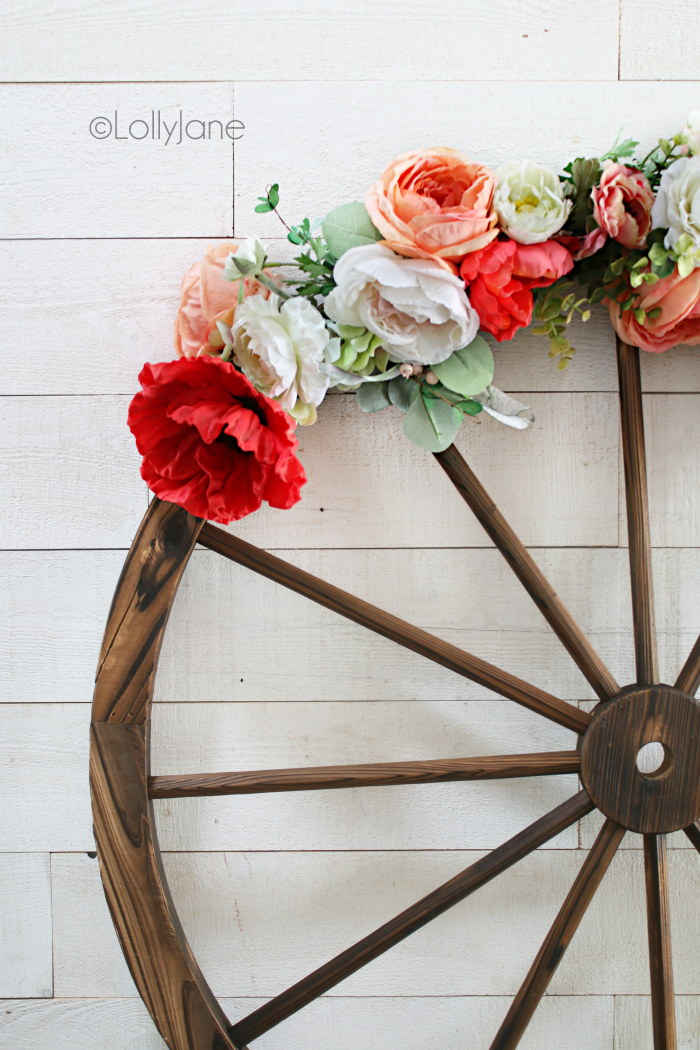 How to make a floral wagon wheel wreath, perfect for summer! Such a fun and easy summer wreath idea, love this farmhouse style wreath. #wreathdiy #diywreath #summerwreath #farmhousewreath #wreathdecor