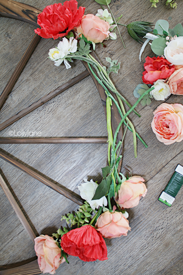 How to make a wagon wheel wreath using florals and eucalyptus leaves. Such a pretty summer wreath decoration. #diy #wreath #summerwreath #summerdecor #wagonwheel #wagonwheelwreath