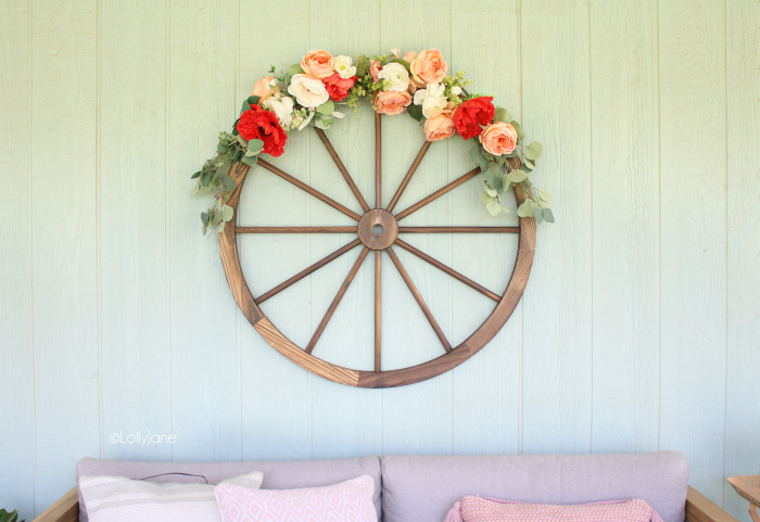 Create your summertime outdoor oasis with this colorful summer porch decor. Learn to make this easy summer wagon wheel wreath with florals and faux greens. So fun! #summerdecor #porchdecor #summerporch #wreathideas 