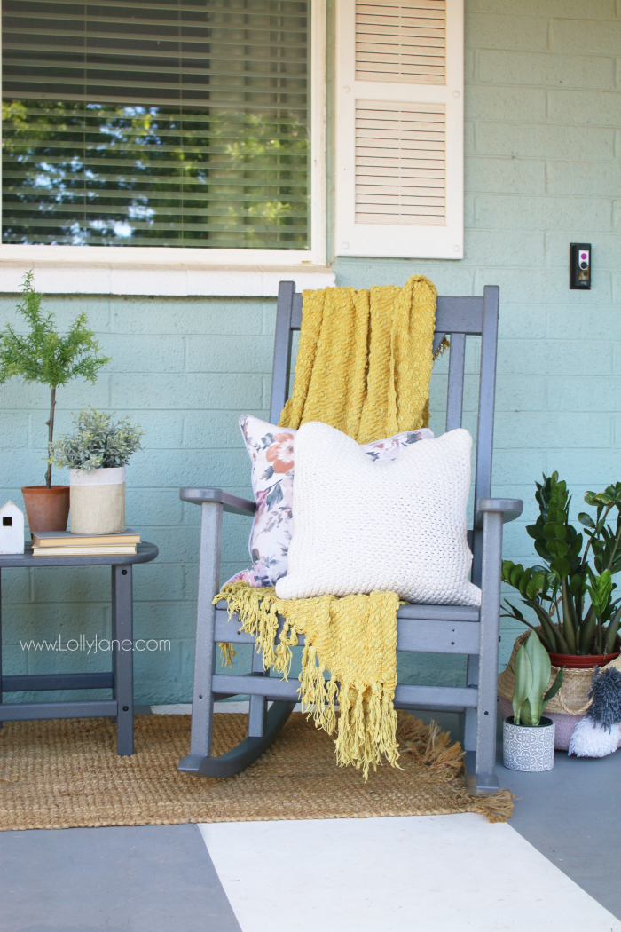 Love the pop of color on this farmhouse front porch! Love these gray rocking chairs with the x back, so cute! #farmhousefrontporch #porchdecor #farmhousestyle #rockingchairs #farmhouserockingchairs