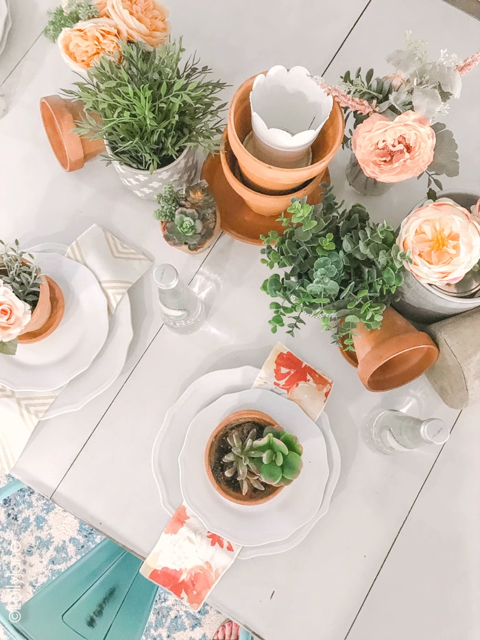 Creating a tablescape doesn't need to be complicated... pair leftover flower pots with fresh or faux greenery + florals and simple add dinnerware. Perfect base for any occasion! #tablescape #summer #summerdecorating #summertablescape