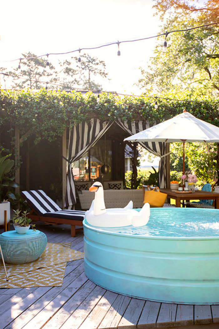 Love this aqua painted stock tank pool is sitting on her deck for quick dips, doesn't it look inviting? You know we love color so the aqua really caught our eye. #stocktank #stocktankpool #tankpool #stockpool #stockpooldiy #stockpoolideas