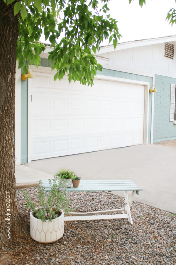 I love my colorful farmhouse: aqua painted brick with happy yellow farmhouse lights make me smile when I get home. #farmhouse #bluehouse #aquahouse #aquaexterior #yellowlight #farmhousestyle #farmhouseexterior