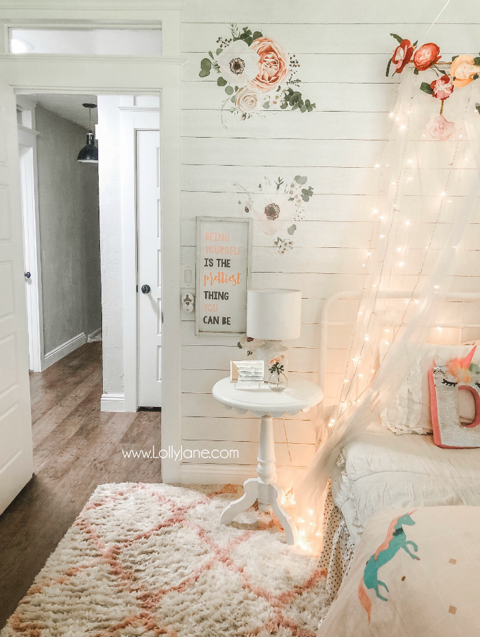 DIY Floral Bed Canopy | Learn how easy it is to put together a floral bed canopy wih a tulle mosquito netting and floral bunting and twinkle lights! #girlsroom #homedecor #homeaccessories #diy #howto #bedcanopy #floralcanopy #fairylightscanopy